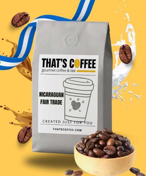 Gray bag of "That’s Coffee" Nicaraguan Fair Trade coffee sits beside a bowl of organic coffee beans, with splashes of coffee and milk in the background.