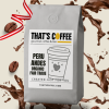 A bag of That's Coffee Peru Andes organic Fair Trade Coffee Beans, with scattered coffee beans and splashes of coffee in the background.